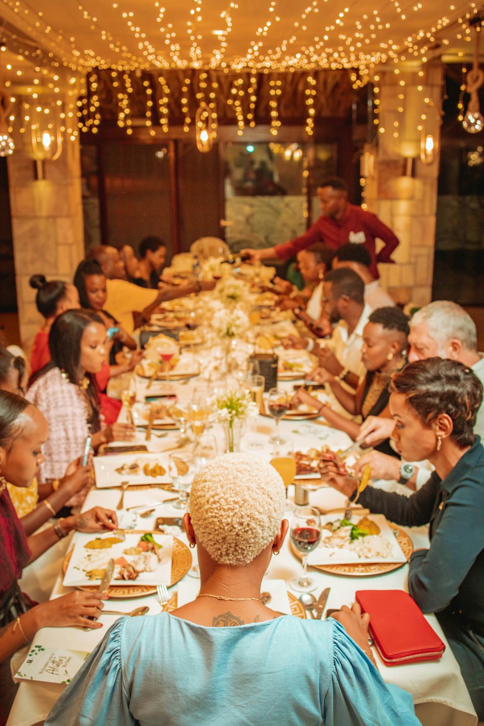 Des gens attablés et discutant lors d'un dîner festif.