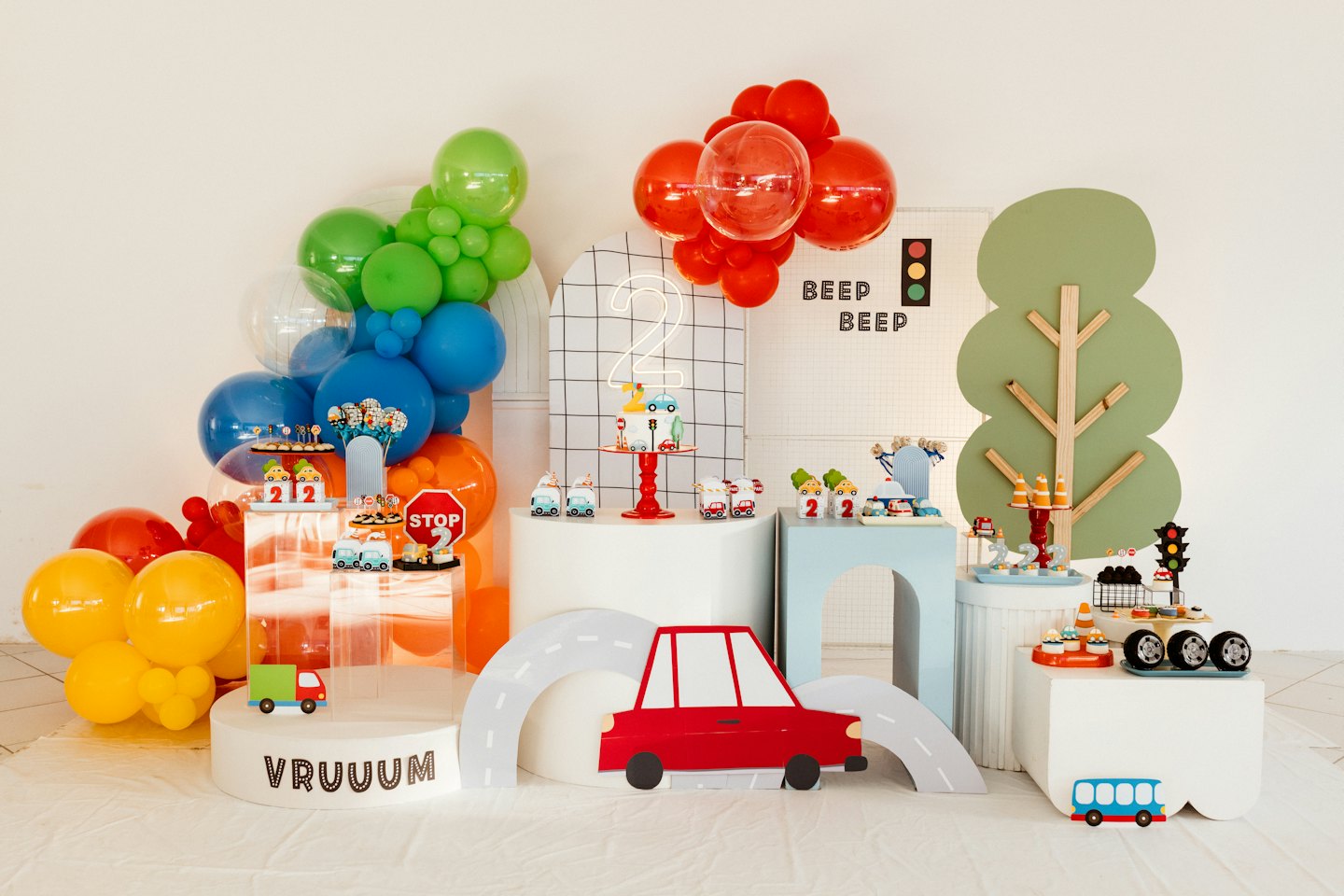 Décorations de fête d'anniversaire sur le thème des transports avec des jouets et des ballons.