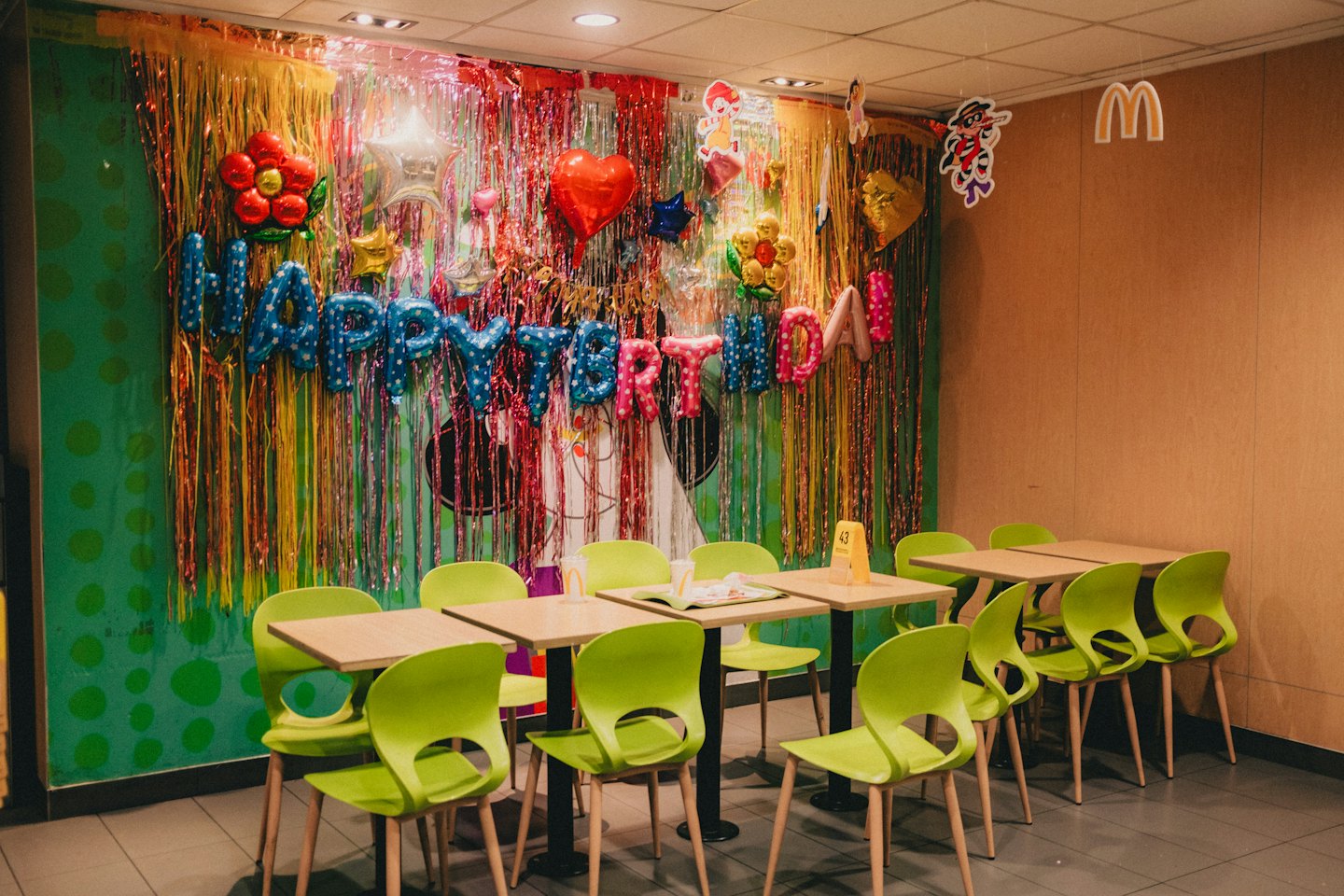 Salle de fête décorée de ballons et de guirlandes pour un anniversaire.