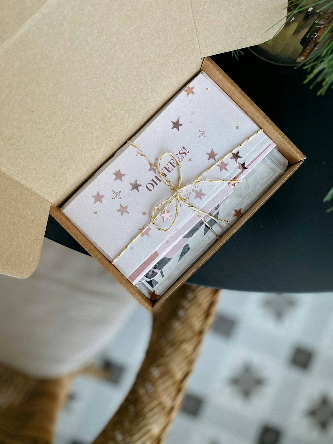 Coffret cadeau avec étoiles or rose et confettis dans une boîte ouverte.