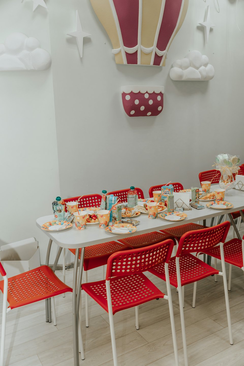 Table dressée pour une fête avec des assiettes colorées et des décorations.